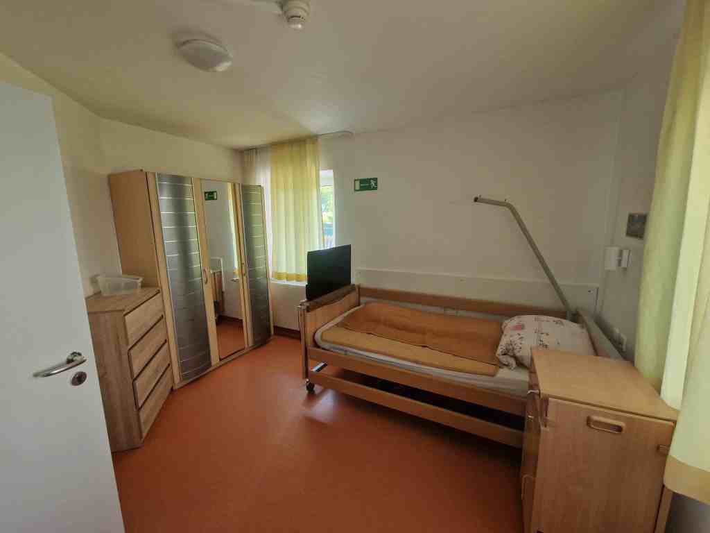 Bewohnerzimmer mit Pflegebett und Schrank im Haus am Grünland
